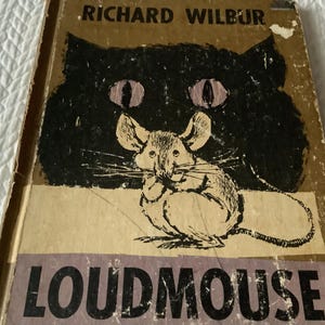 May include: Vintage book cover for "Loudmouse" by Richard Wilbur. The cover features a black cat silhouette with pink eyes and a detailed illustration of a mouse. The title "Loudmouse" is in bold, dark letters.