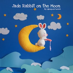 Puede incluir: Un conejo blanco de crochet se sienta en una luna creciente amarilla, sobre un fondo azul con nubes blancas y estrellas. El texto "Jade Rabbit on the Moon" y "By @aquariwool" está en la parte superior de la imagen.