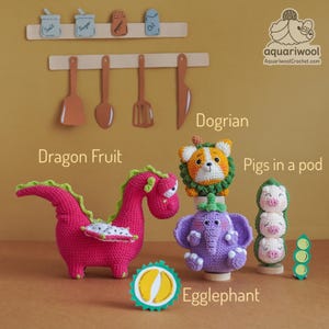 May include: A collection of handmade crochet toys, including a pink dragon, a dog-like creature, an elephant, and three pigs in a pod. The toys are displayed with a decorative kitchen-themed background, featuring miniature utensils and spice jars.