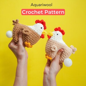 May include: Two crocheted chicken toys, one brown and one beige, with red and yellow accents. The chickens are holding white eggs in their beaks. The image is captioned "Aquariwool Crochet Pattern".