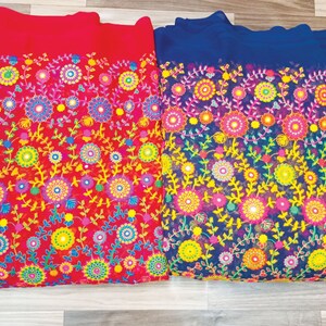 May include: Two pieces of fabric, one red and one blue, are displayed. Both fabrics feature a vibrant floral embroidery design with colorful flowers and leaves. The embroidery includes shades of yellow, pink, blue, and green.