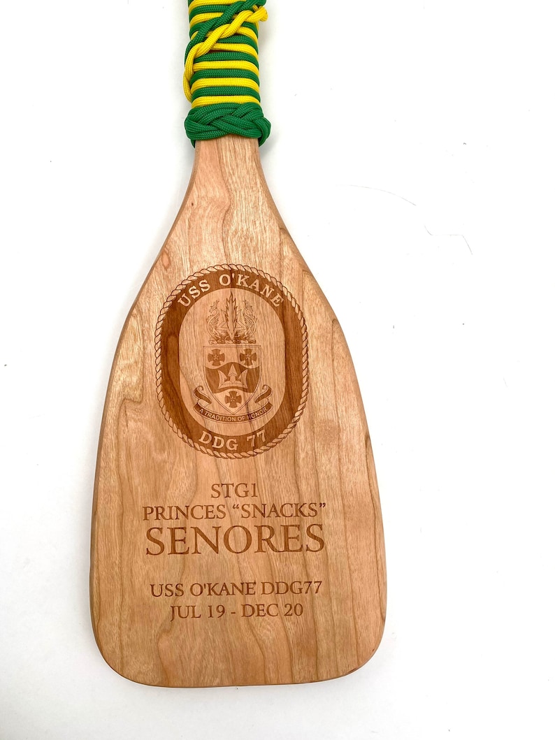 Military paddle made of top grade cherry wood with custom laser engraving.  Navy, USCG, Marines, Air Force, Army, Joint Chiefs, any logo you would like.  Price includes all front side engraving and paracord wrap plus free shipping.
