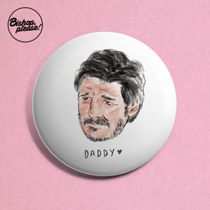 May include: White button with a black and white illustration of a man's face with a beard and the text "DADDY" with a heart.