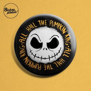 May include: Black and white button featuring a Jack Skellington face and the text "Hail the Pumpkin King-All King-All Hail the Pumpkin" in yellow.
