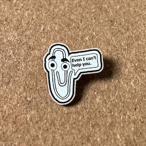 May include: A wooden pin shaped like a paperclip with googly eyes and a speech bubble that says "Even I can't help you."