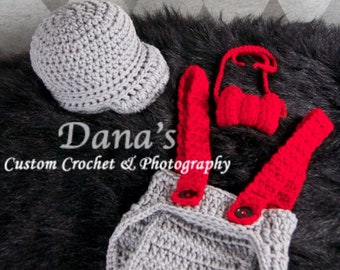 Puede incluir: Sombrero, mono y pajarita de crochet gris con detalles rojos. El texto "Dana's Custom Crochet & Photography" es visible en la imagen.