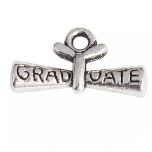 May include: Silver charm in the shape of a graduation cap with the word "GRADUATE" on it.