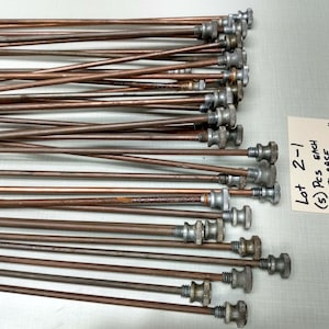 May include: A lot of 25 steel case rods with a length of 2 5/8 inches. The rods are copper colored and have a silver colored threaded end with a knob.