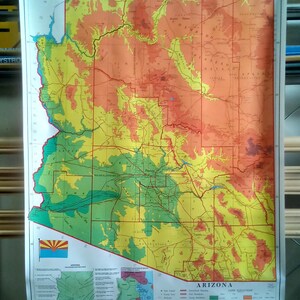 May include: A vintage map of Arizona with a color-coded key showing land elevation. The map is printed on a white background and features a legend with various symbols and text. The map is titled "Arizona" and includes the state flag in the bottom left corner.