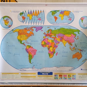 May include: A large, pull-down Nystrom wall map of the world featuring a central political map, North and South Polar views, and globe projections. The map displays continents and oceans in various colors with clear text labels for countries.