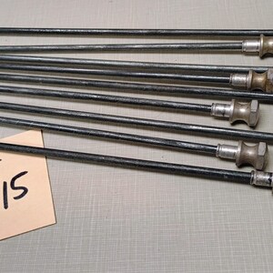 May include: A lot of eight silver and black metal rods with a rounded end. The rods are arranged in a row on a gray surface. A tan tag with the text "Lot # 15" is in the lower left corner of the image.