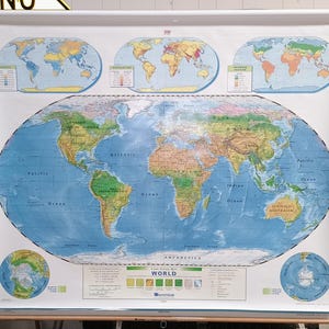 May include: A large, wall-mounted pull-down world map featuring a central oval projection of the continents and oceans. The map includes smaller inset maps showing rainfall, population, and growing regions, along with polar views and a legend.