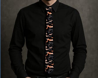 May include: A black tie with a repeating pattern of orange, gray, and black bat silhouettes. The tie is worn with a black button-down shirt and black pants. The background is a solid gray.