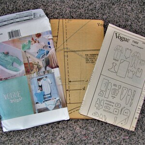 May include: A Vogue Baby sewing pattern for a baby onesie, with instructions and pattern pieces. The pattern number is 7002.