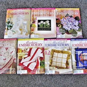 May include: A collection of ten Machine Embroidery & Textile Art magazines. The magazines feature a variety of embroidery projects, including Christmas ornaments, a quilt, a pillow, and a stained glass window. The magazines are all in good condition and have colorful covers.