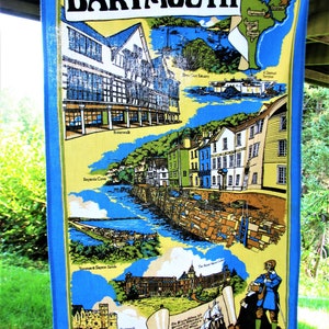 May include: A colorful illustration of Dartmouth, England, featuring a map of the area, a view of the town's waterfront, and a depiction of Dartmouth Castle. The text "DARTMOUTH" is displayed in a large, bold font at the top of the image.