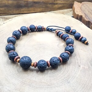 May include: A black lava rock and wood bead bracelet with a black cord.