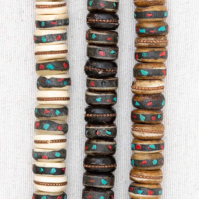 Puede incluir: Tres hebras de cuentas con diferentes patrones de colores. Las cuentas est&aacute;n hechas de madera y tienen un acabado natural. Las cuentas est&aacute;n enhebradas en un cord&oacute;n y est&aacute;n listas para ser utilizadas para la elaboraci&oacute;n de joyas.