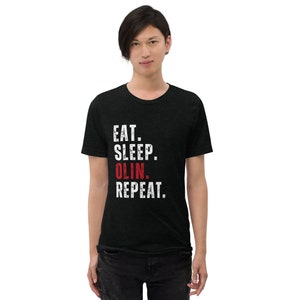 May include: Black t-shirt with white text that reads "Eat. Sleep. Olin. Repeat." The word "Olin" is in red.