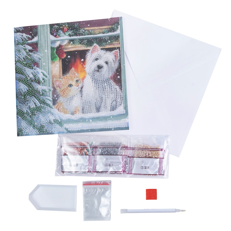 Puede incluir: Kit de pintura de diamantes con una tarjeta de felicitaci&oacute;n que representa un gato y un perro en una escena invernal. El kit incluye un sobre blanco, diamantes, una bandeja y un l&aacute;piz.