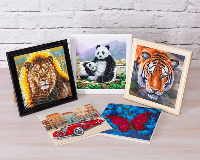 Puede incluir: Una colecci&oacute;n de obras de arte enmarcadas con dise&ntilde;os de cuentas. La obra de arte incluye un le&oacute;n, un panda con su cachorro, un tigre, un coche rojo vintage y una mariposa roja. Los marcos var&iacute;an en color y estilo.