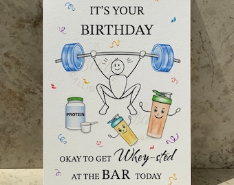 May include: A birthday card with a stick figure lifting weights, a protein powder container, and a shaker bottle. The card says "It's your birthday. Okay to get whey-sted at the bar today."