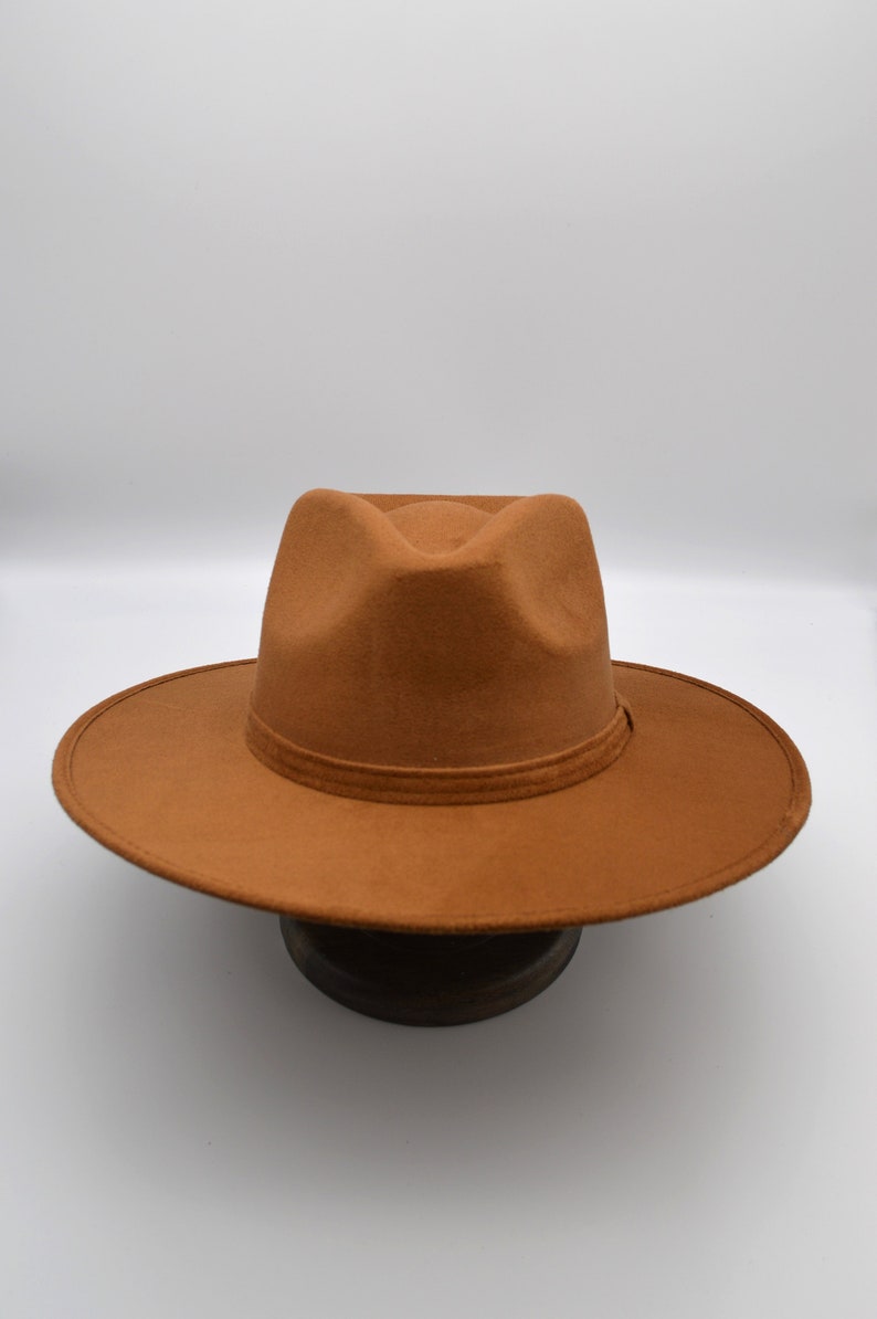 Peut inclure: Un chapeau fedora marron &agrave; large bord. Le chapeau est en feutre et a un design simple.