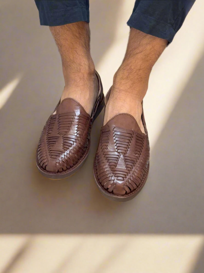 May include: Brown leather sandals with a woven design. The sandals have a closed toe and a flat sole.
