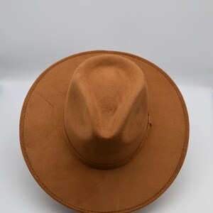 Peut inclure: Un chapeau fedora marron &agrave; large bord et &agrave; calotte l&eacute;g&egrave;rement enfonc&eacute;e.