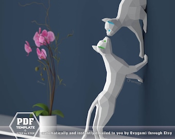Könnte beinhalten: Eine digitale PDF-Vorlage für ein 3D-Papiermodell von zwei weißen Katzen. Die Katzen sind in einer verspielten Pose, wobei eine Katze die andere erreicht. Die Vorlage enthält Schritt-für-Schritt-Anleitungen zum Zusammenbauen des Modells.