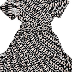 Puede incluir: Vestido estampado en blanco y negro con mangas cortas y cintura fruncida. El vestido presenta un dise&ntilde;o de eslabones de cadena en blanco y beige sobre un fondo negro. La falda tiene un detalle de volantes en capas.