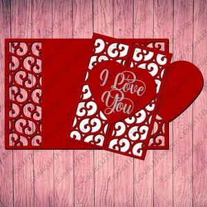 May include: Red and white paper cut-out card with a heart shape and the words "I Love You" inside. The card is designed for Valentine's Day.