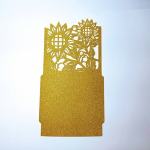 May include: Gold glitter card with a cut-out design of sunflowers and leaves.