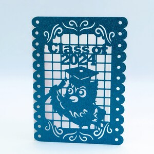 May include: Teal blue paper cutout with a graduation cap and owl design. The cutout has a white grid background and says "Class of 2024".