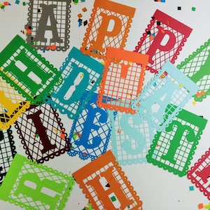 May include: A colourful paper banner spelling out the word "Happy" in different colours. Each letter is cut out of paper and has a decorative border. The banner is ideal for a birthday party or other celebration.