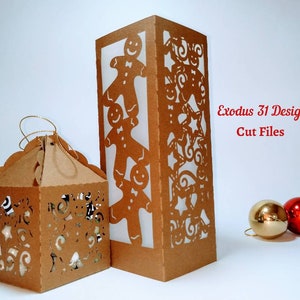 May include: Two brown paper lanterns with cut-out designs. One is a tall rectangular shape with gingerbread men cutouts, and the other is a small, scalloped-edged box. The text "Exodus 31 Designs Cut Files" is in red.