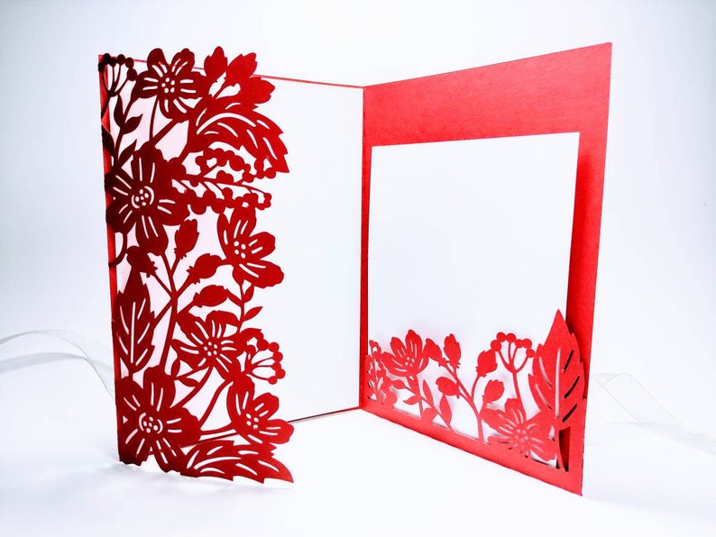 Pu&ograve; includere: Carta rossa con un design floreale ritagliato. La carta &egrave; piegata a met&agrave; e l'interno &egrave; vuoto.