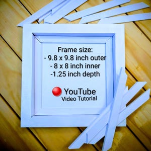 Puede incluir: Un marco de fotos cuadrado blanco con el texto "Frame size: - 24,9 x 24,9 cm exterior - 20,3 x 20,3 cm interior -3,2 cm de profundidad" y "YouTube Video Tutorial". Varias tiras de madera blancas dispersas.