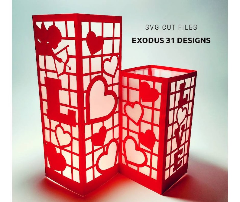May include: Two red paper lanterns with cut-out designs of hearts and the word "LOVE". The lanterns are lit from inside, creating a warm glow. SVG cut files by Exodus 31 Designs.