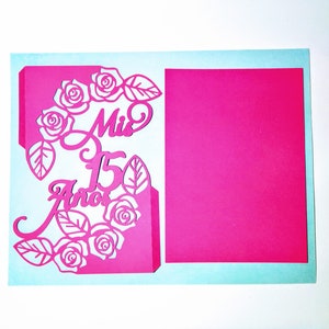 May include: A pink card with a cut-out design of roses and leaves. The text "Mis 15 Anos" is also cut out of the card.