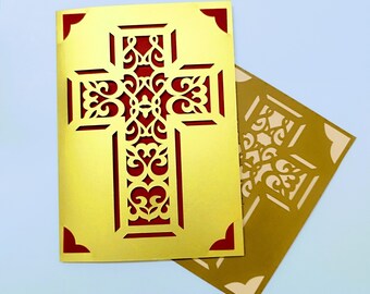 May include: A gold card with a red, intricately designed cross cut out of the center. The card is folded in half, with the cross design visible on both sides.
