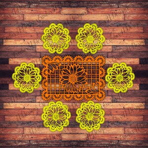 Puede incluir: Cinco servilletas de papel amarillas con un dise&ntilde;o de girasol. Una servilleta de papel naranja m&aacute;s grande con un dise&ntilde;o de girasol est&aacute; en el centro. Las servilletas est&aacute;n sobre un fondo de madera.