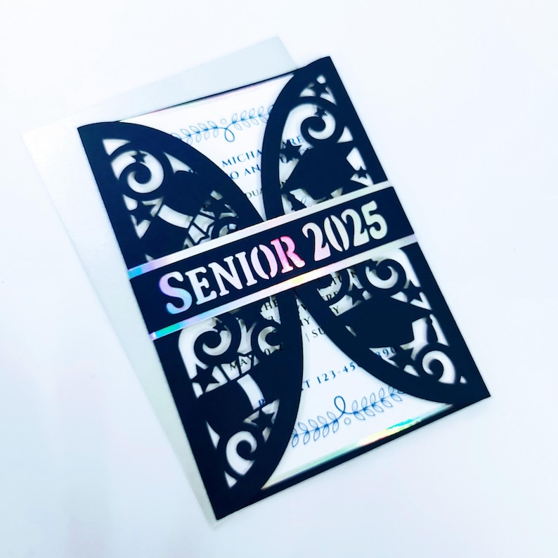 May include: Black laser cut invitation with a holographic iridescent strip that says "Senior 2025". The invitation is decorated with a floral design and graduation caps.