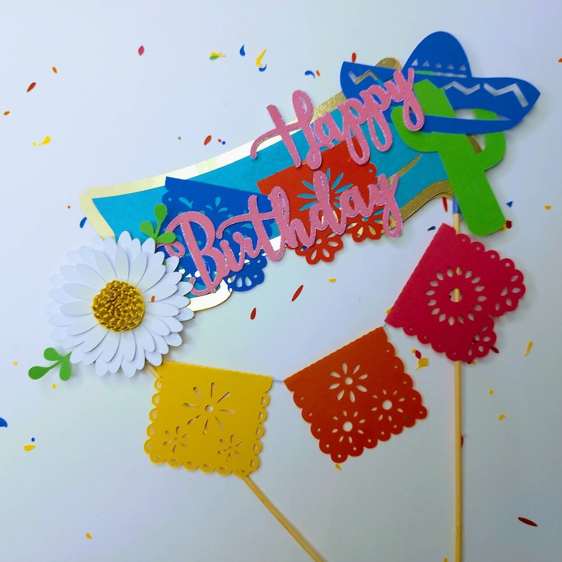 May include: A set of colorful paper party decorations with a "Happy Birthday" banner, a sombrero, a cactus, and a string of flags. The decorations are perfect for a fiesta-themed birthday party.