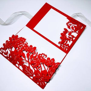 Pu&ograve; includere: Invito di nozze rosso tagliato al laser con un design floreale. L'invito &egrave; piegato a met&agrave; e ha un interno bianco.