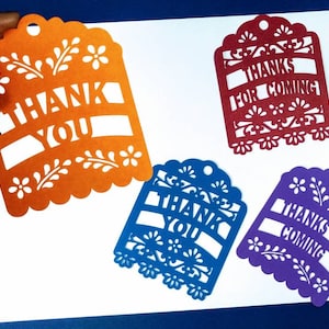 Peut inclure: Quatre étiquettes de remerciement découpées dans du papier orange, rouge, bleu et violet. Les étiquettes ont un design décoratif avec des fleurs et des feuilles. Le texte sur les étiquettes est "Merci", "Merci d'être venu", "Merci" et "Merci d'être venu".