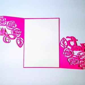 May include: A pink card with a cut-out design of roses and leaves. The words "Mrs" and "And" are cut out of the card.