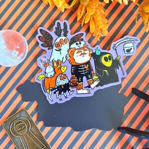 May include: A sticker featuring a group of cartoon Halloween characters on a purple background. The characters include a ghost, a skeleton, a grim reaper, and other whimsical creatures, all holding jack-o'-lanterns. The sticker has a black border and is set against a striped orange and black background.