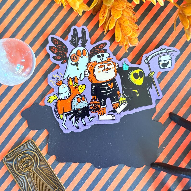 May include: A sticker featuring a group of cartoon Halloween characters on a purple background. The characters include a ghost, a skeleton, a grim reaper, and other whimsical creatures, all holding jack-o'-lanterns. The sticker has a black border and is set against a striped orange and black background.