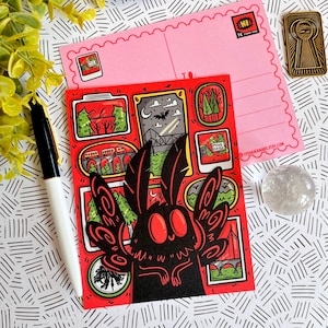 May include: A red and black postcard featuring a cartoon moth with large eyes and wings. The postcard is decorated with images of a forest, a bridge, and a sign that says "Mine Closed".